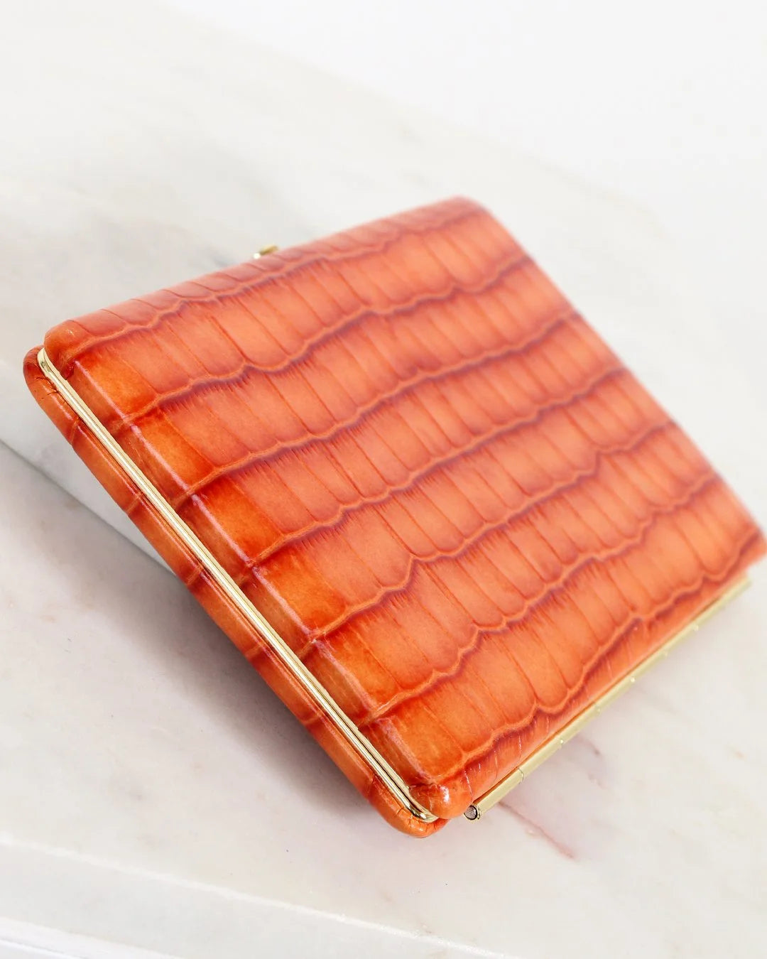 Orange crocodile-patterned wallet on a light background