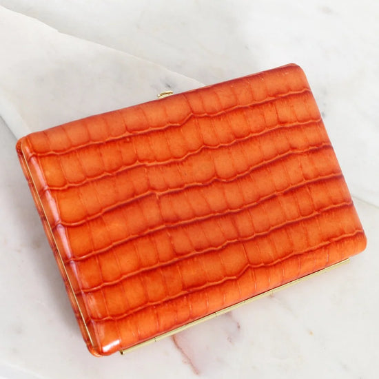Orange textured clutch bag on a light background