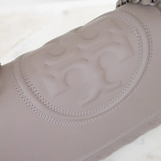 Close-up of a gray leather handbag with chain detail on a white background