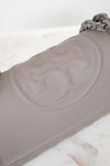 Close-up of a gray leather handbag with chain detail on a white background