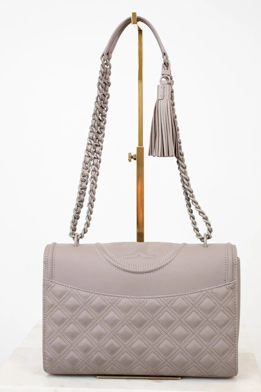Quilted gray handbag with a chain strap on a white background
