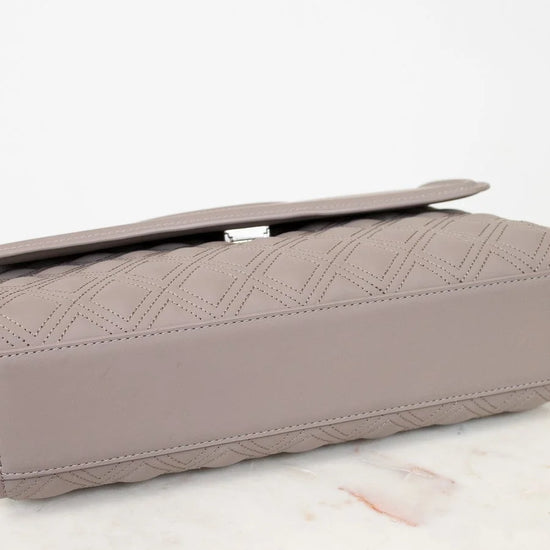Quilted clutch bag on a light surface