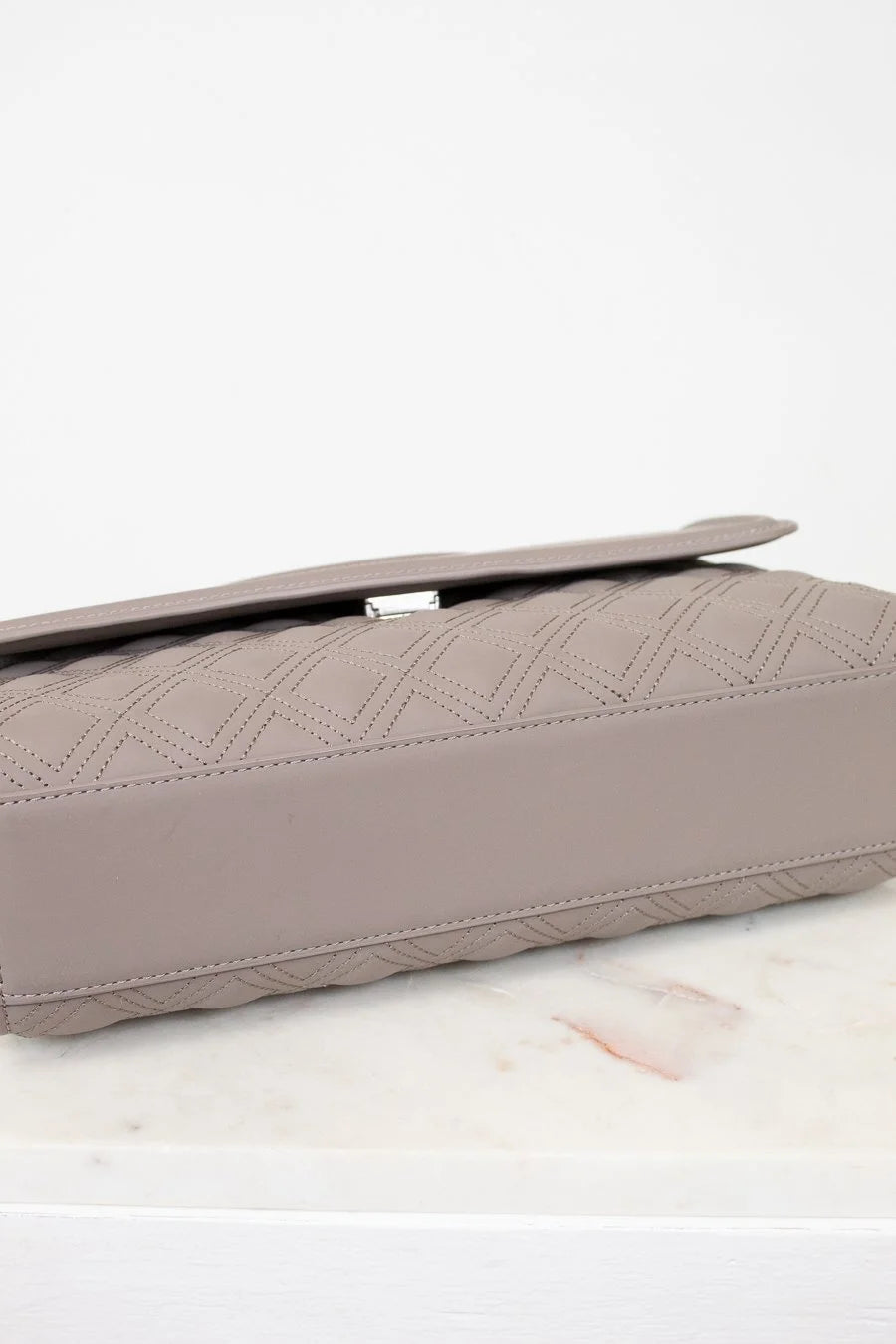 Quilted clutch bag on a light surface