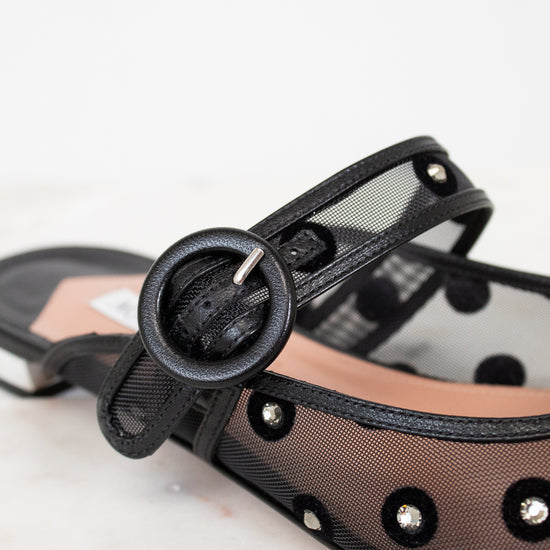 Black strappy sandal with mesh overlay on a light background