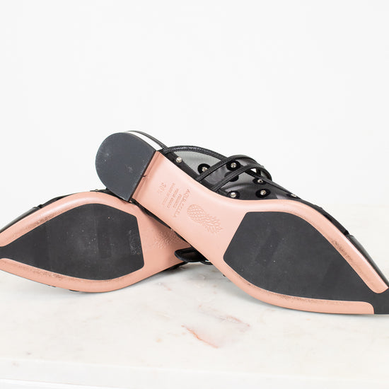 Close-up of a shoe sole with black and pink design on a white background