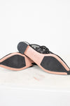 Close-up of a shoe sole with black and pink design on a white background