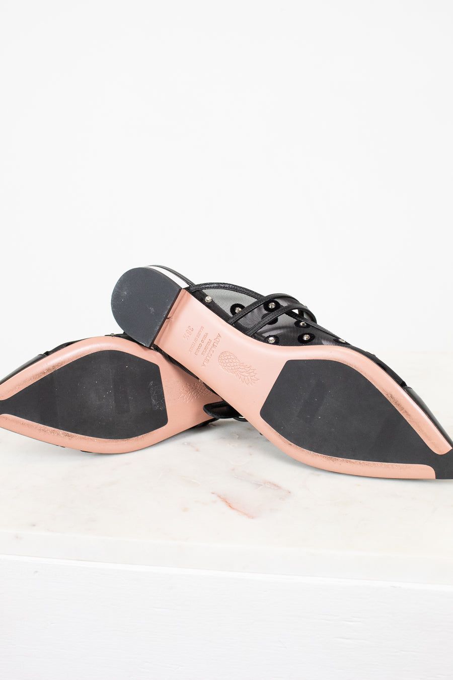 Close-up of a shoe sole with black and pink design on a white background