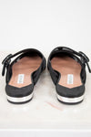 Black mules with white soles on a light gray background