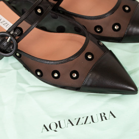 Pair of Aquazzura shoes on a light green background