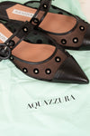 Pair of Aquazzura shoes on a light green background